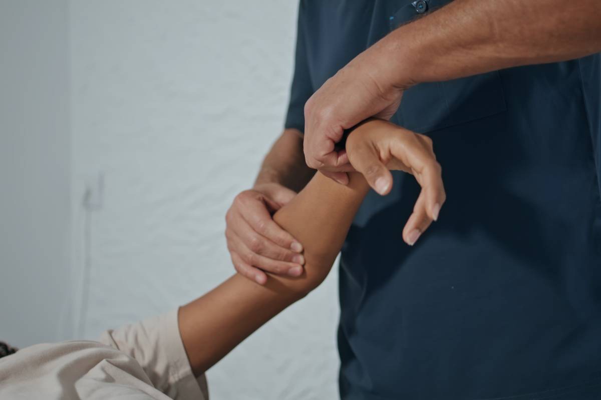 Osteopath hands pressing arm on recovery session closeup. Specialist do recovery