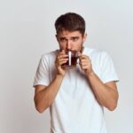 man with a cup of tea in a bag on a light background Hot drink cropped view model