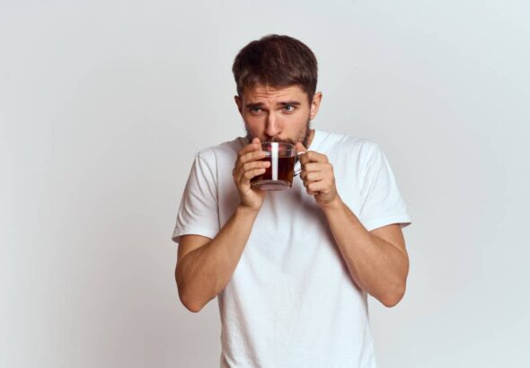 man with a cup of tea in a bag on a light background Hot drink cropped view model