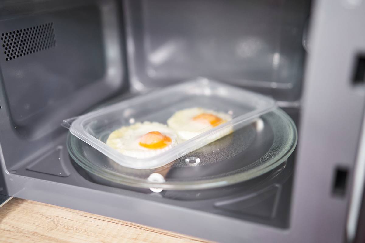 Ready to eat fried eggs in plastic packaging inside microwave. Supermarket fast food concept