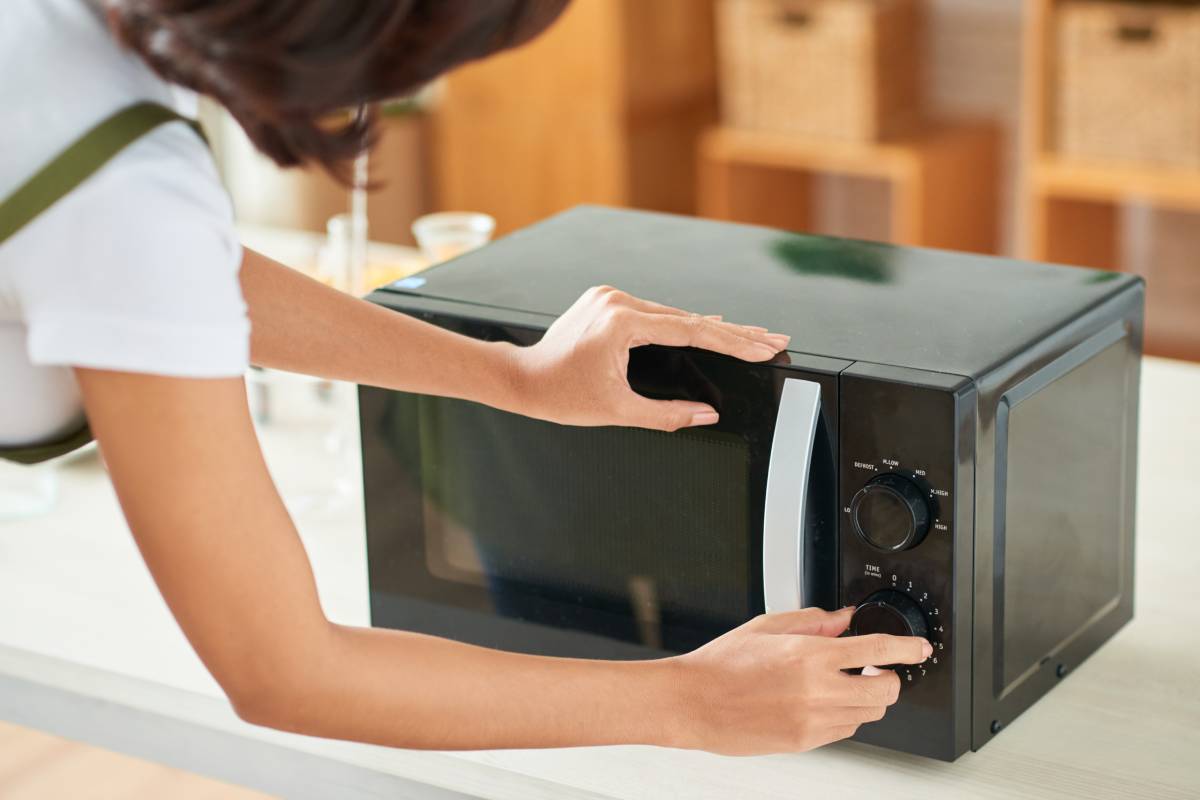 Woman Setting Time on Microwave