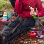 Hiker sitting on ground and eating meal