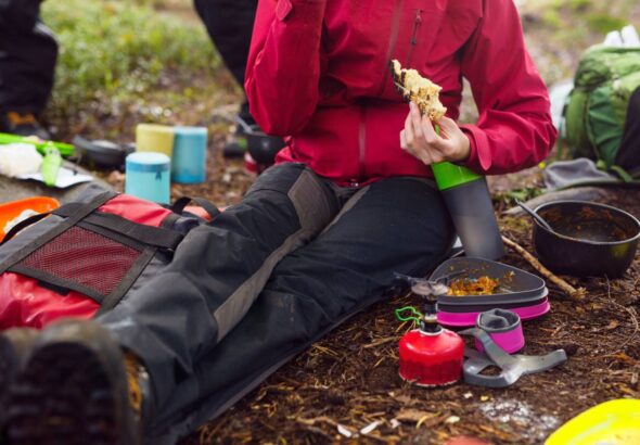 Hiker sitting on ground and eating meal