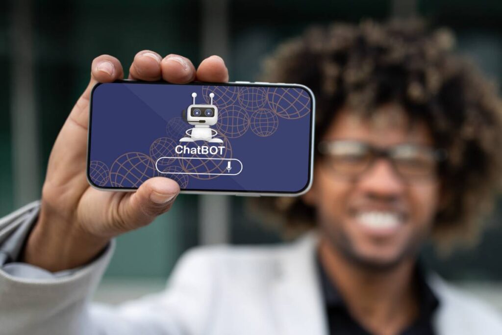 Positive african american entrepreneur showing phone with chatbot