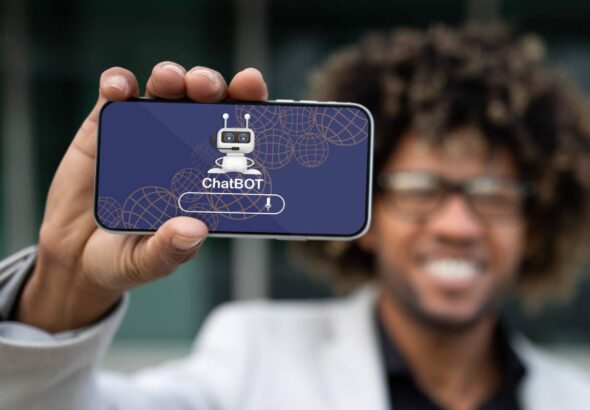 Positive african american entrepreneur showing phone with chatbot