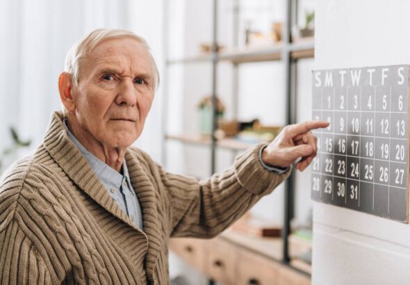 old man touching calendar looking at camera memory loss