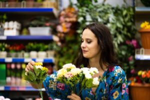 Woman picking up Florist from a bucket in a florist shop